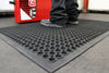 Industrial anti-fatigue mat with debris-capture design