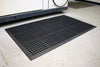 Anti-fatigue industrial mat with debris-trapping feature