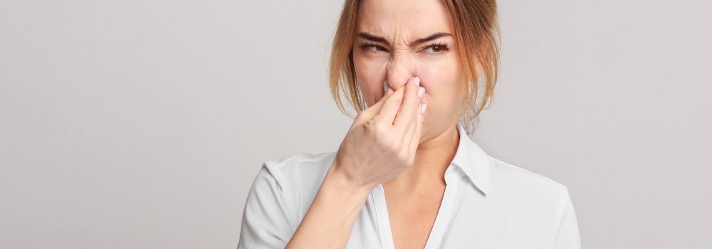 Woman pinching nose because of a Bad Smell