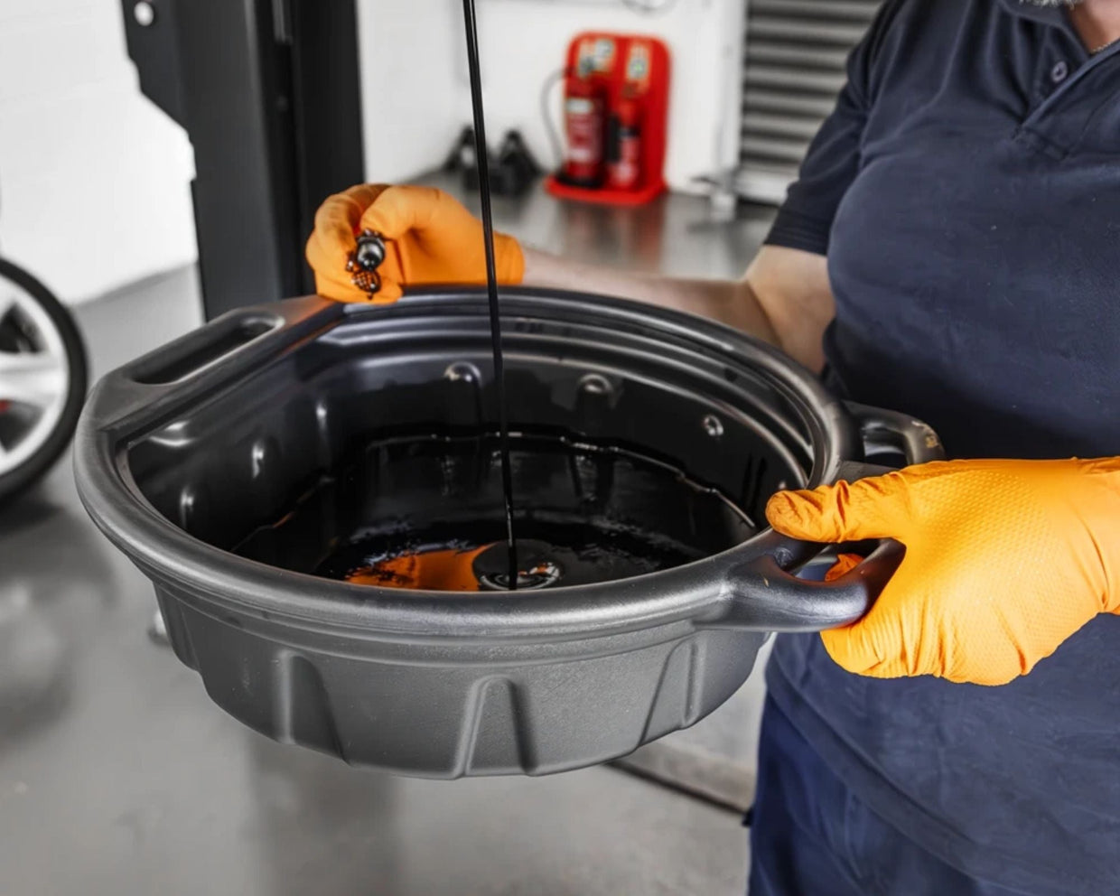 Plastic drain pan catching engine oil