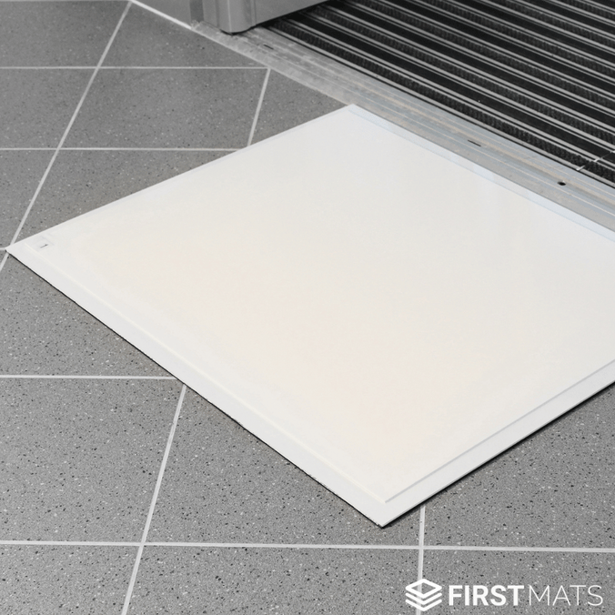 White tacky mat on a grey tiled floor