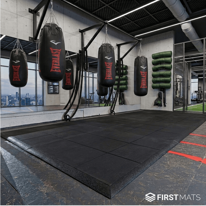 Interlocking rubber gym mat tiles being used underneath punch bags in a boxing gym