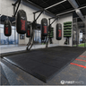 Interlocking rubber gym mat tiles being used underneath punch bags in a boxing gym