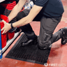 Kneeling on a rubber workstation anti-fatigue mat