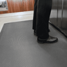Person standing on the Kitchen and Catering floor mat in a cafe 