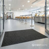 Black mat on a grey floor in a modern canteen interior.
