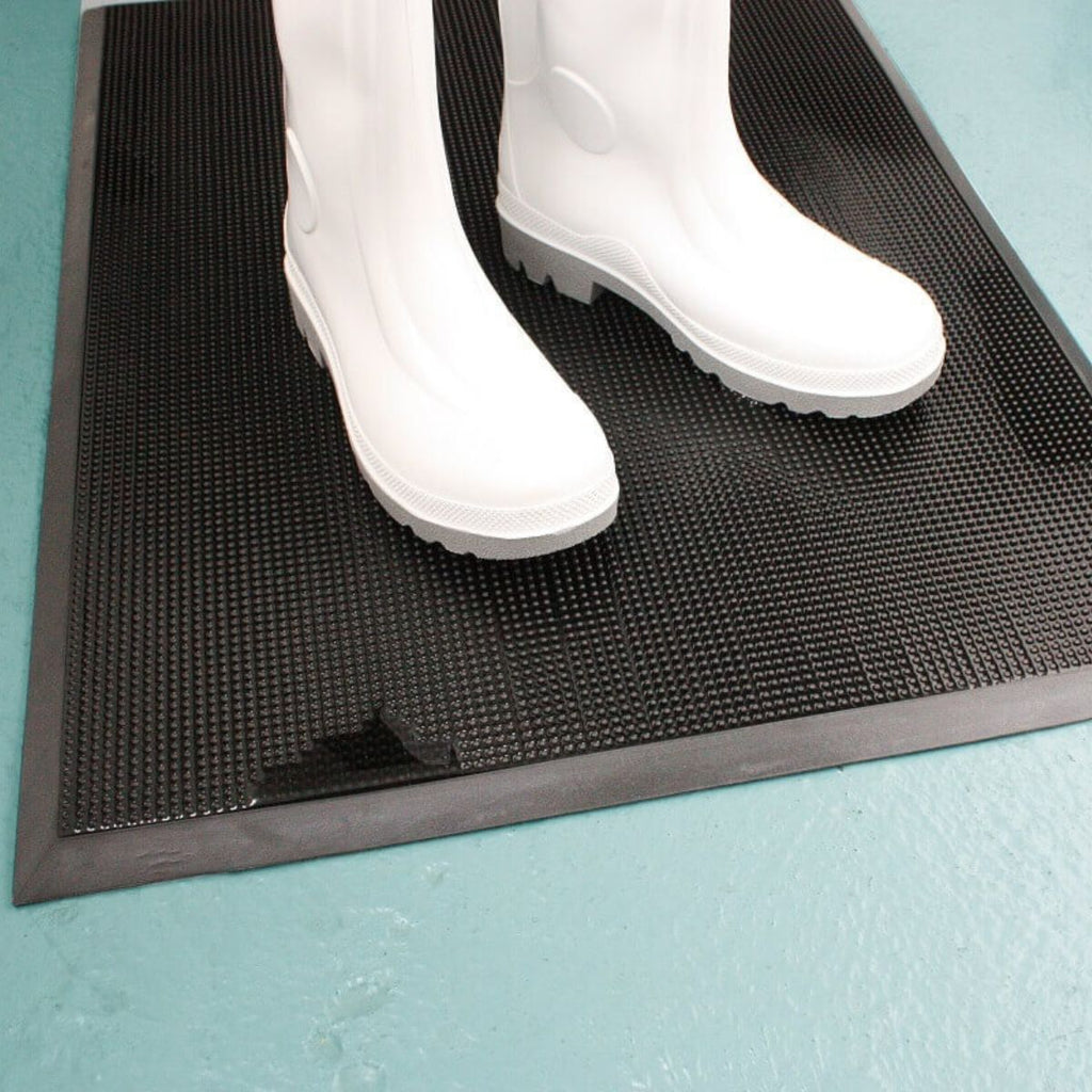 White wellies on disinfectant footbath mat