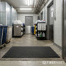 Commercial cleaning area with black mat, cleaning supplies, and carts.