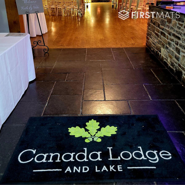 Floor mat with 'Canada Lodge and Lake' logo on a tiled floor.