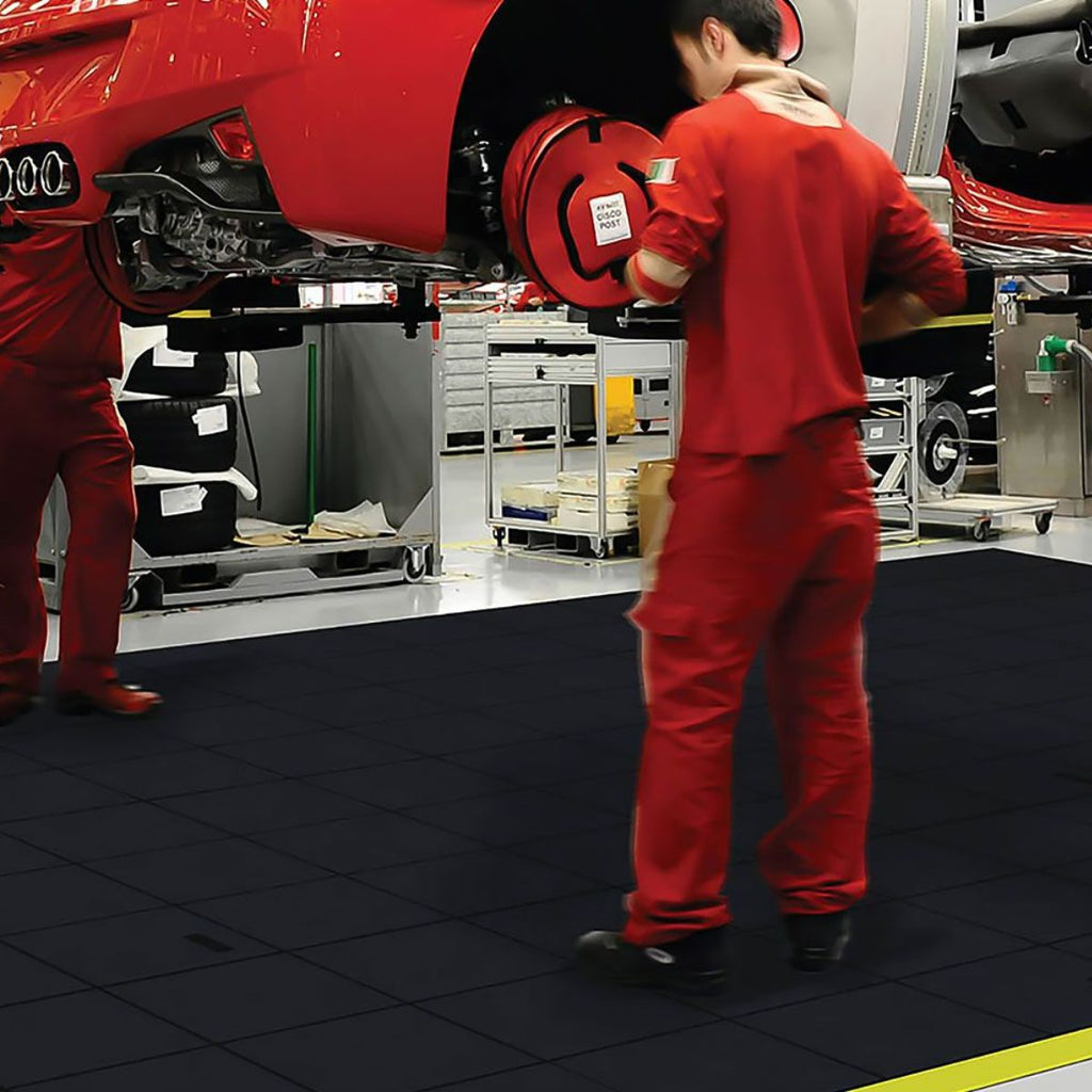 Working on a car in a garage with interlocking rubber mats