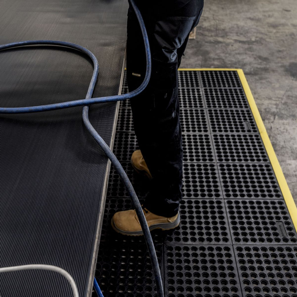 Standing on interlocking rubber mats in a workshop
