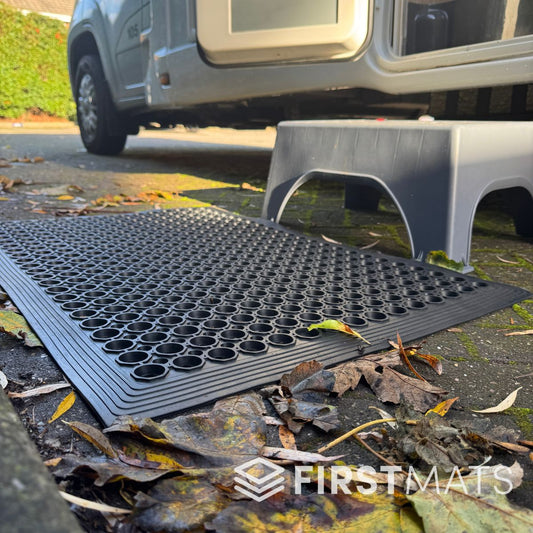 Black rubber floor mat with honeycomb pattern outside a motorhome