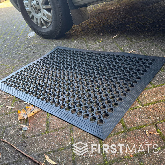 Black rubber floor mat with honeycomb pattern outside a motorhome
