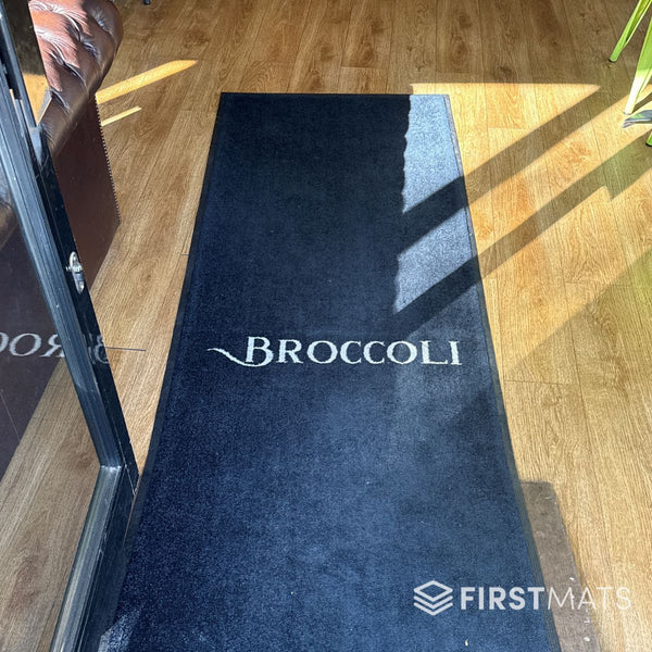Black logo mat in a restaurant / Broccoli Cafe