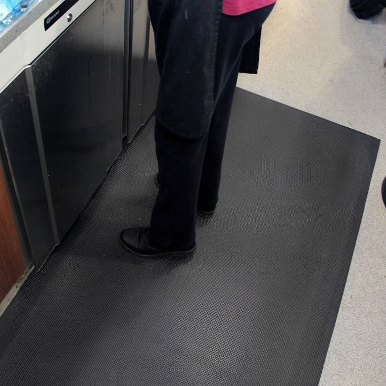 Black PinnacleMat anti-fatigue floor mat designed for kitchen and catering environments to provide comfort and reduce strain for standing workers.