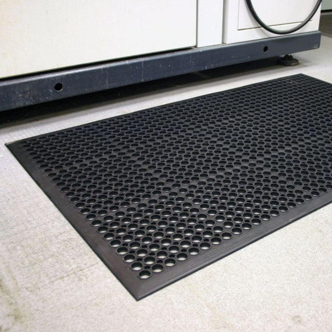 Anti-fatigue industrial mat with debris-trapping feature