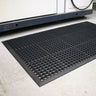Anti-fatigue industrial mat with debris-trapping feature
